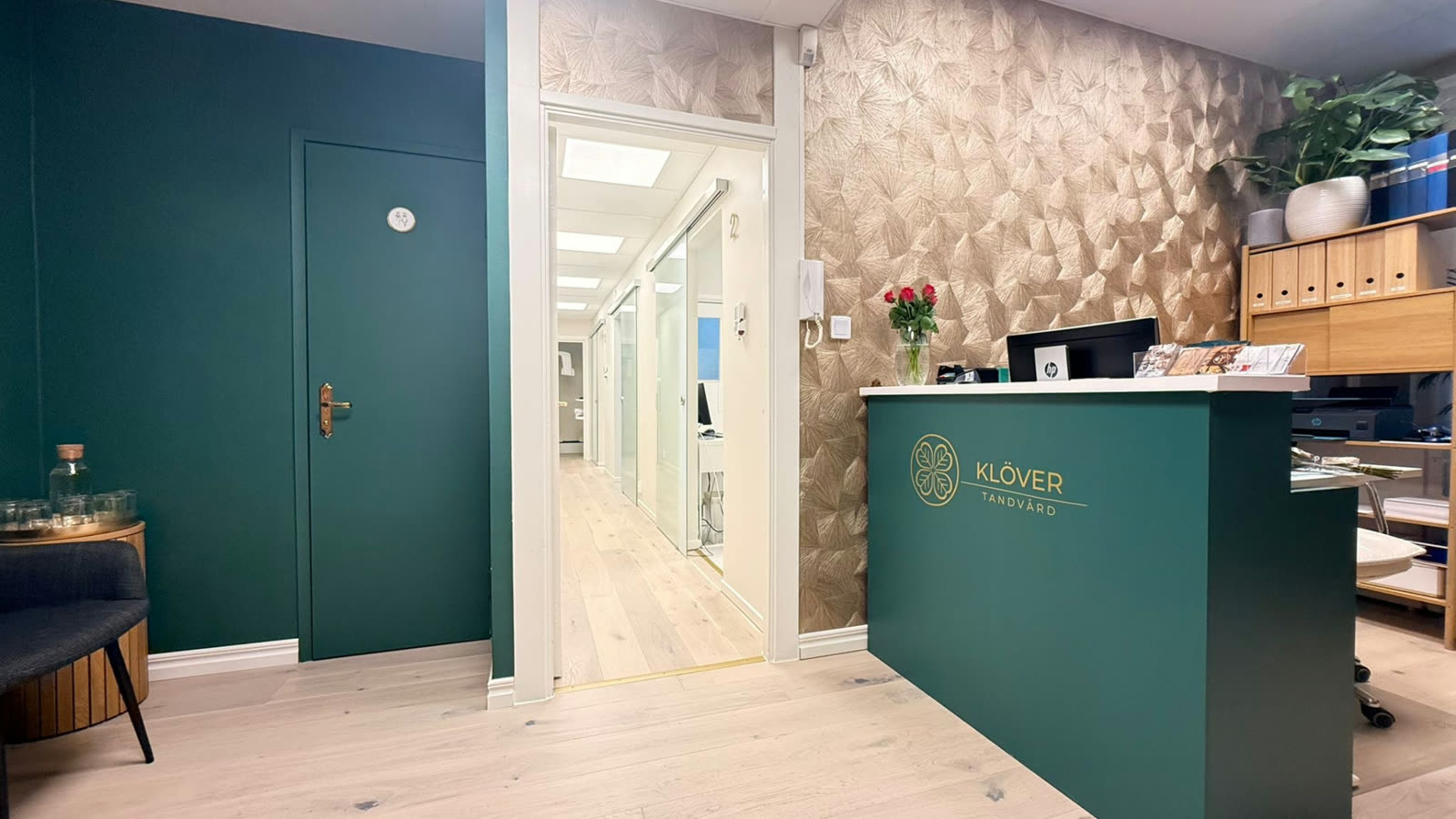 Korridor och reception på Klöver Tandvård med klinikens gröna dörrar